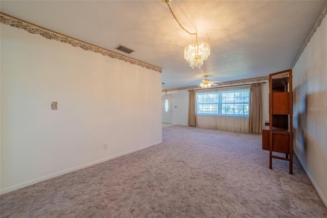 carpeted empty room featuring a textured ceiling, ceiling fan with notable chandelier, and ornamental molding