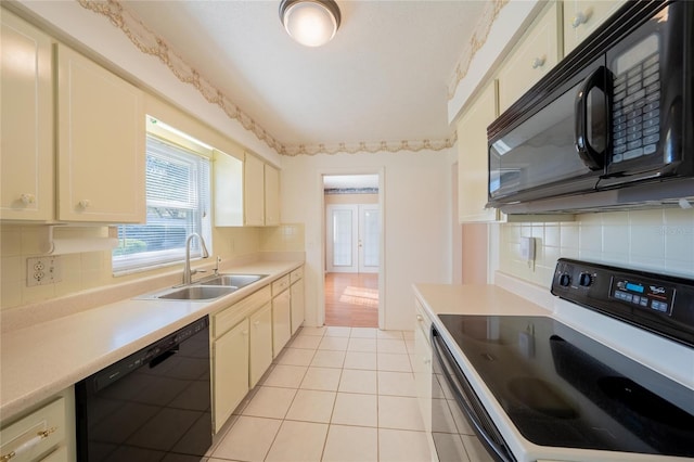 kitchen featuring sink, cream cabinets, decorative backsplash, light tile patterned floors, and black appliances