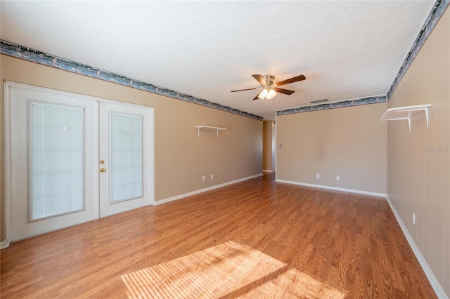 spare room with ceiling fan, french doors, a textured ceiling, and hardwood / wood-style flooring