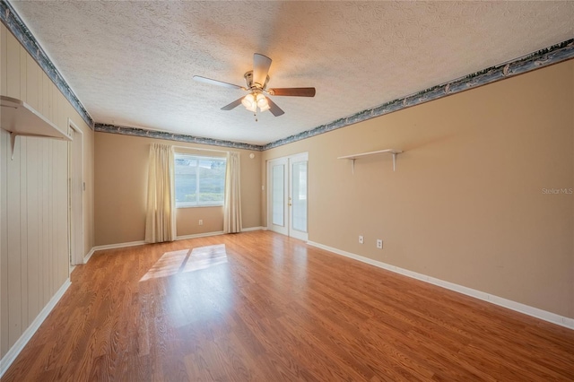 empty room featuring ceiling fan, a textured ceiling, and light wood-type flooring