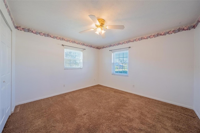 spare room featuring carpet and ceiling fan