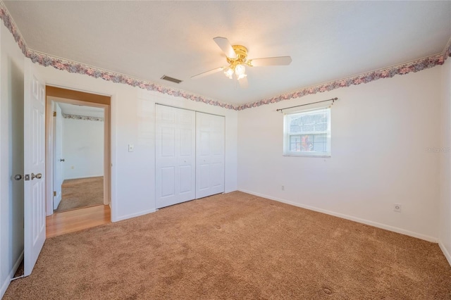 unfurnished bedroom with ceiling fan, carpet floors, and a closet