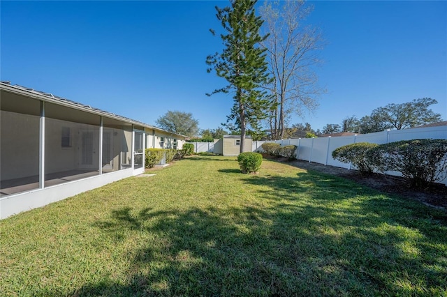 view of yard featuring a storage unit and a sunroom