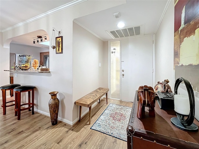 entryway with crown molding and light wood-type flooring