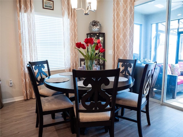 dining area with hardwood / wood-style floors and a chandelier