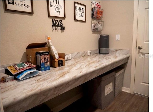 bar featuring light stone countertops and dark wood-type flooring