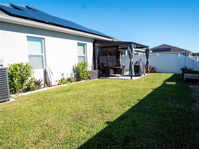 view of yard featuring a patio, central air condition unit, and a sunroom