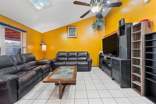 living room with a textured ceiling, ceiling fan, light tile patterned floors, and lofted ceiling