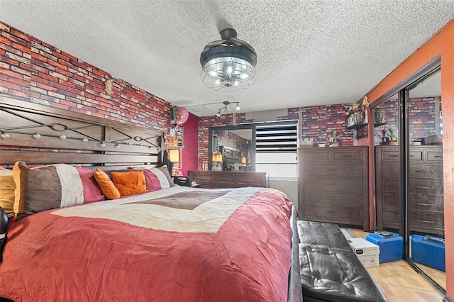 bedroom with access to exterior, brick wall, and a textured ceiling