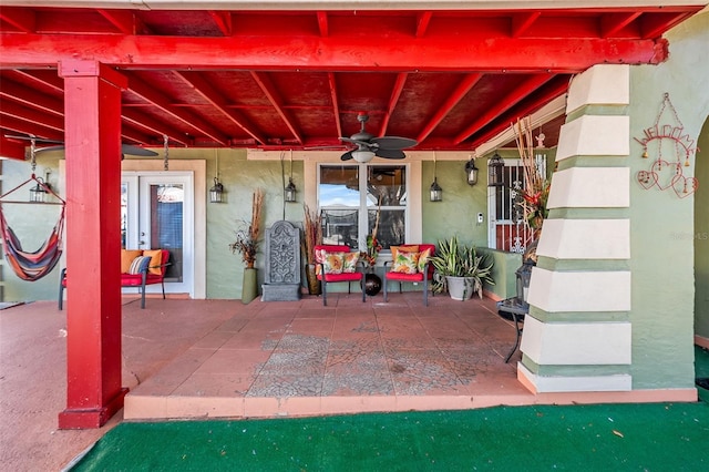 view of exterior entry featuring ceiling fan and a patio area