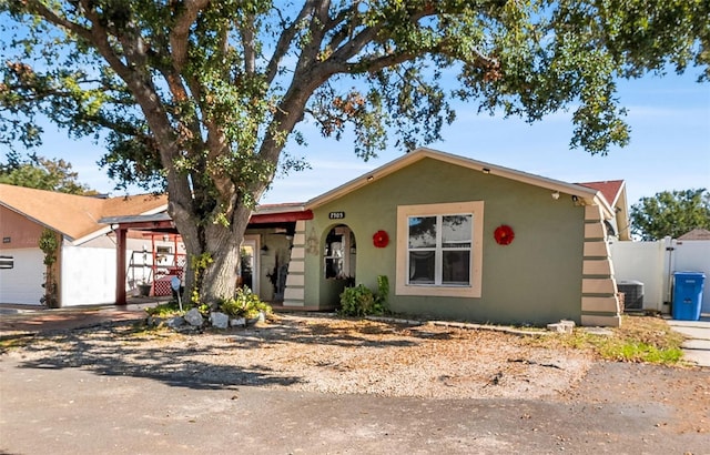 view of front of property with a garage and central AC