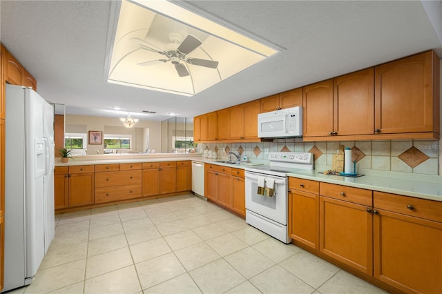 kitchen featuring ceiling fan with notable chandelier, white appliances, tasteful backsplash, and light tile patterned flooring