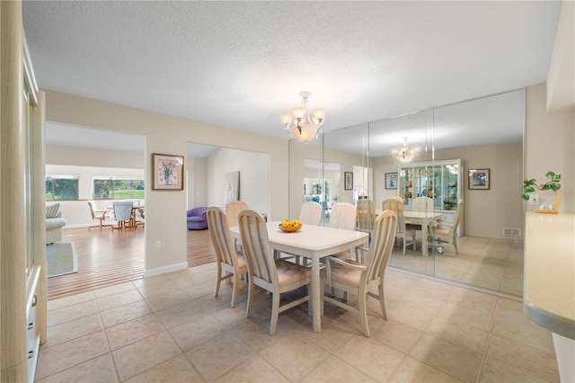 3401 Avenida Madera Unit B, Bradenton, FL 34210 - dining area featuring a chandelier, light tile patterned floors, baseboards, and a textured ceiling