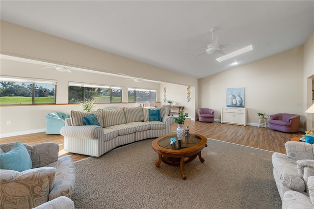 living room featuring ceiling fan, a healthy amount of sunlight, light wood-type flooring, and lofted ceiling