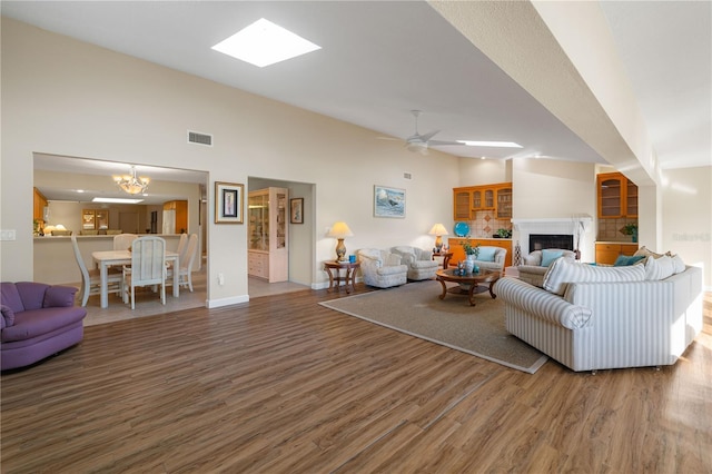 3401 Avenida Madera Unit B, Bradenton, FL 34210 - living room featuring wood finished floors, a fireplace, a ceiling fan, baseboards, and a chandelier