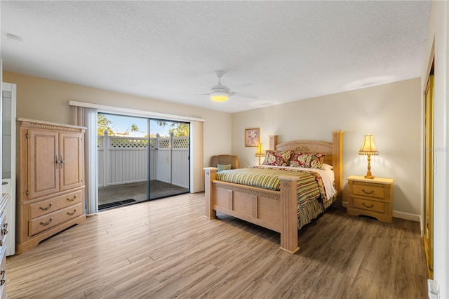 bedroom featuring ceiling fan, light hardwood / wood-style floors, access to exterior, and a textured ceiling