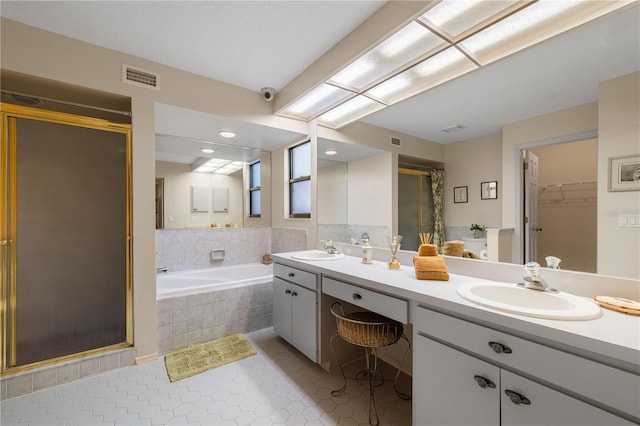 bathroom featuring vanity, tile patterned flooring, and plus walk in shower