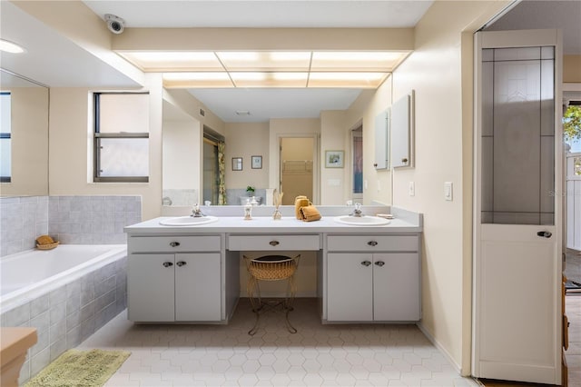 bathroom featuring vanity and tiled tub