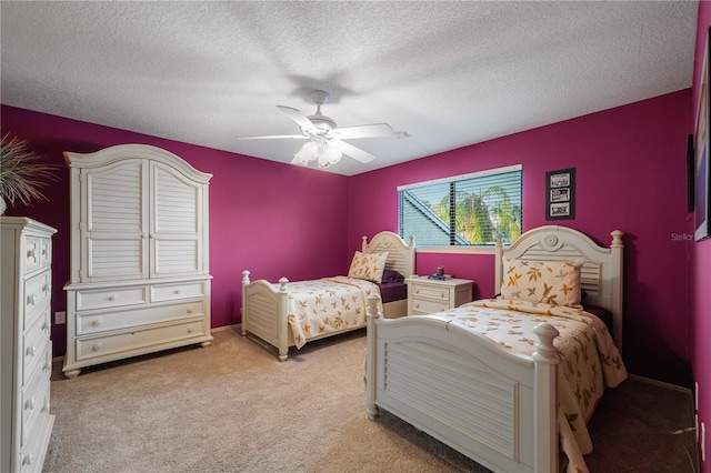 bedroom featuring a textured ceiling, light colored carpet, and ceiling fan