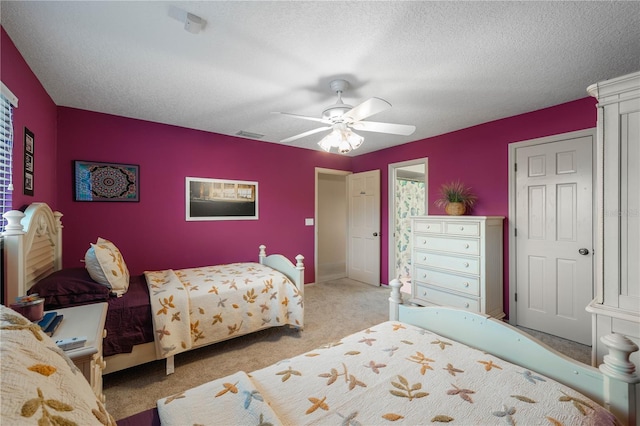 carpeted bedroom with a textured ceiling and ceiling fan