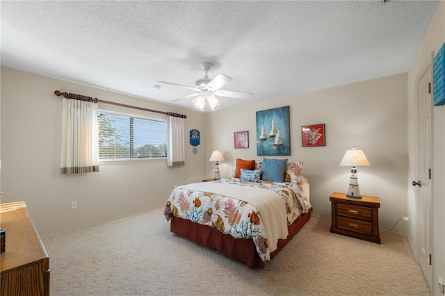 carpeted bedroom featuring ceiling fan and a textured ceiling