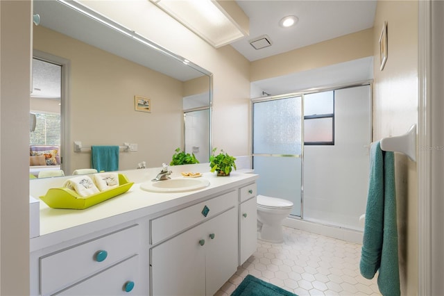 bathroom featuring tile patterned flooring, vanity, toilet, and walk in shower