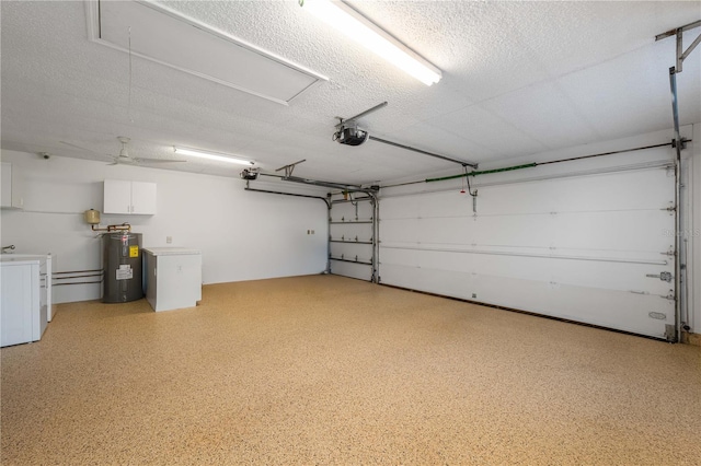 garage with washing machine and dryer, a garage door opener, ceiling fan, and water heater