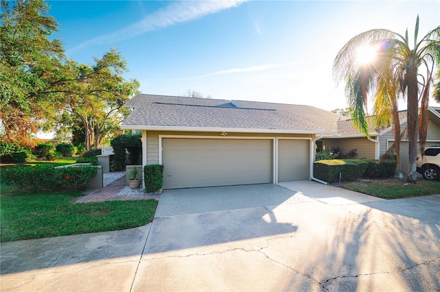 3401 Avenida Madera Unit B, Bradenton, FL 34210 - view of front facade featuring concrete driveway, an attached garage, and a shingled roof