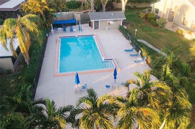 view of swimming pool featuring an outbuilding, a yard, and a patio