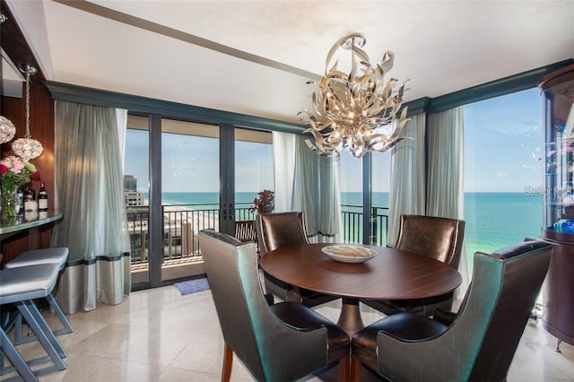 dining space with french doors, a water view, and an inviting chandelier