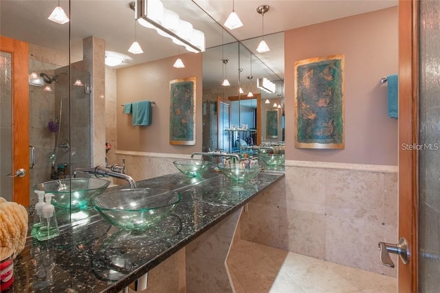 bathroom featuring tile patterned flooring, tile walls, and sink