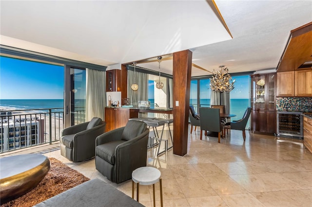 living room featuring a view of the beach, a water view, and beverage cooler