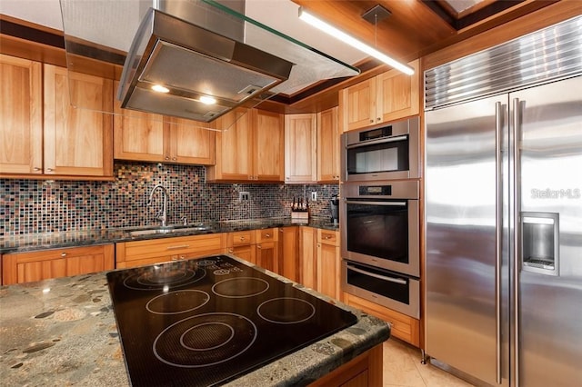 kitchen with backsplash, pendant lighting, sink, stainless steel appliances, and dark stone counters