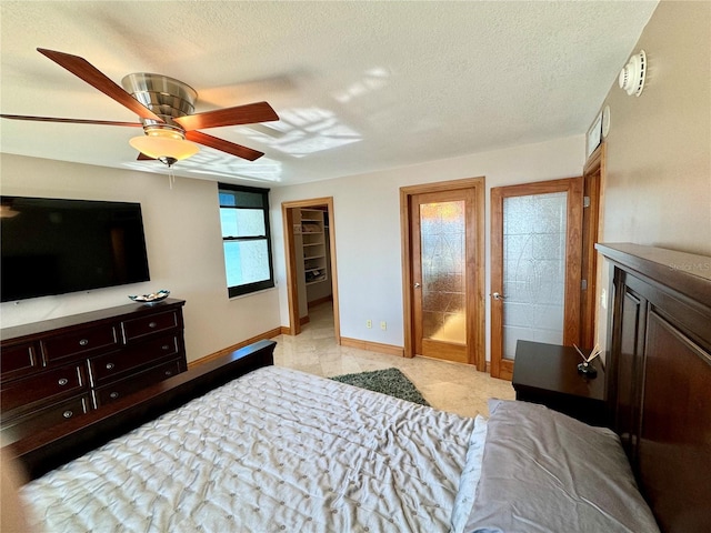 bedroom with ceiling fan, a closet, a spacious closet, and multiple windows