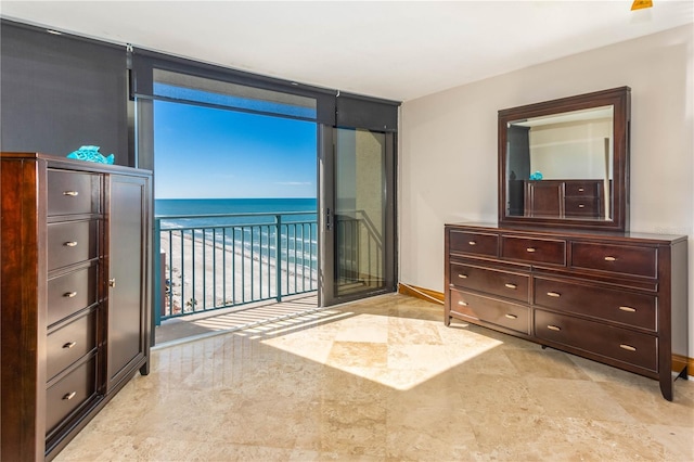 bedroom with a water view and a view of the beach