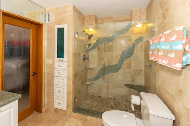 bathroom with toilet, tile walls, a shower with door, and vanity