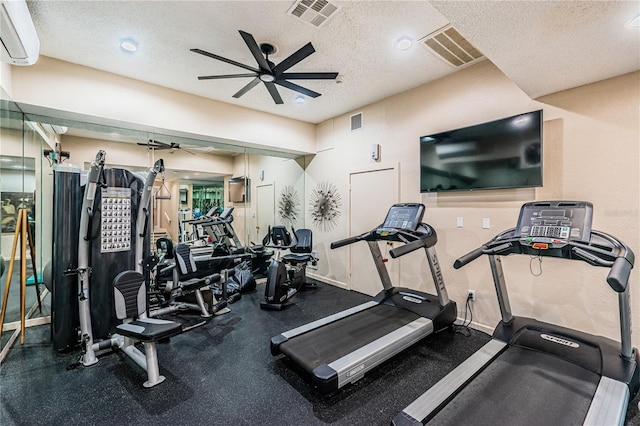 gym featuring ceiling fan, a textured ceiling, and a wall mounted air conditioner