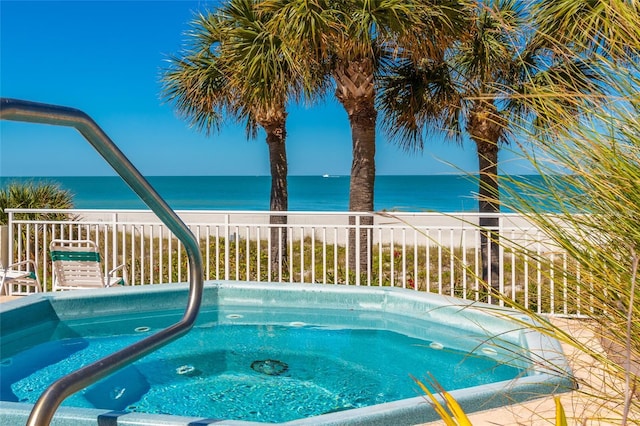 view of pool featuring an in ground hot tub and a water view