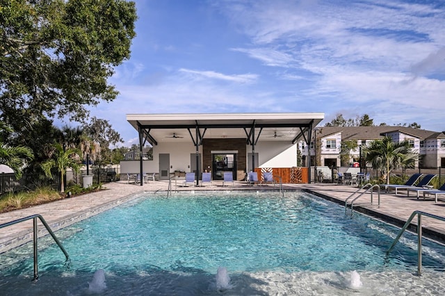 view of swimming pool featuring ceiling fan and a patio area