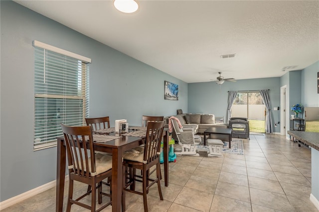 dining space with light tile patterned floors, a textured ceiling, and ceiling fan