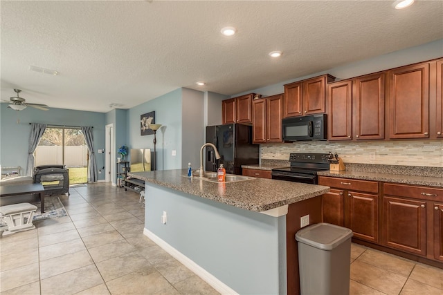 kitchen with a textured ceiling, a kitchen island with sink, and black appliances