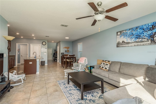 living room featuring ceiling fan, light tile patterned floors, and a textured ceiling