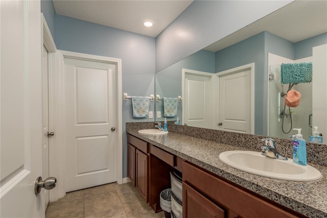 bathroom with tile patterned floors, vanity, and walk in shower