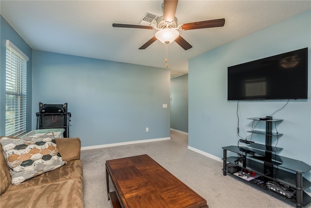 carpeted living room with a textured ceiling and ceiling fan