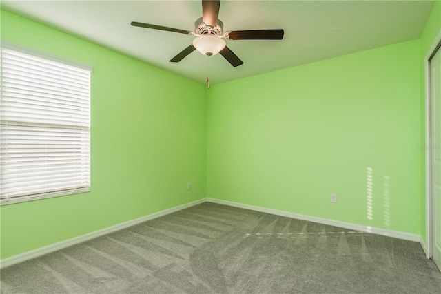 carpeted spare room with ceiling fan