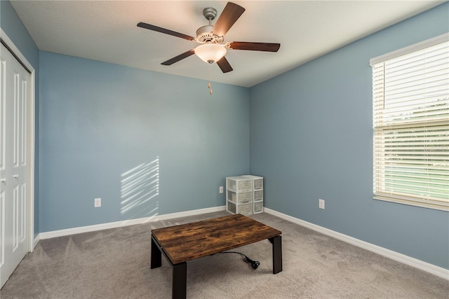 living area with ceiling fan, a healthy amount of sunlight, and light colored carpet