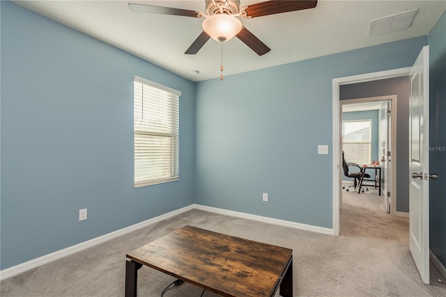 interior space with ceiling fan and light colored carpet