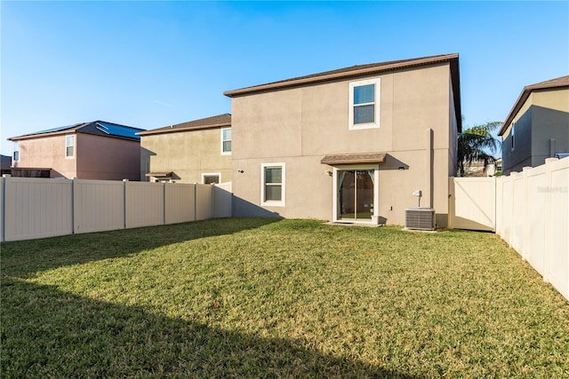 back of property featuring a yard and central AC