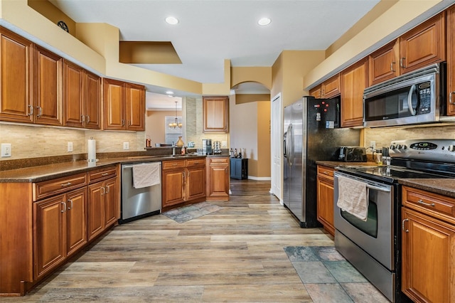 kitchen featuring decorative backsplash, sink, stainless steel appliances, and light hardwood / wood-style floors