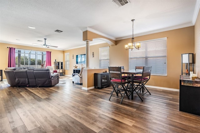 dining area with hardwood / wood-style floors, ceiling fan with notable chandelier, and ornamental molding